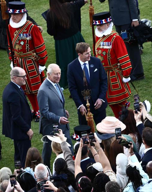 Britain's King Charles III talks to guests during a Royal Garden Party at Buckingham Palace, in London, on May 14, 2026, celebrating the 50th Anniversary of the King’s Trust. (Photo by Henry NICHOLLS / POOL / AFP)