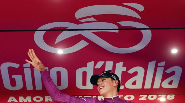 Soudal Quick-Step French rider Paul Magnier, wearing the points classification mauve jersey (Maglia Ciclamino)celebrates on podium after the 6th stage of the Giro d'Italia 2026 - Tour of Italy cycling race between Paestum and Naples, southern Italy on May 14, 2026. (Photo by Luca Bettini / AFP)
