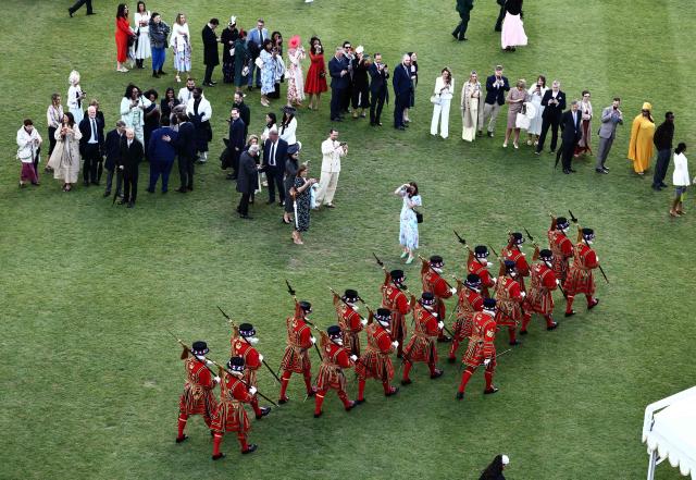Guests take photographs of members of the The Kings's Body Guard of the Yeomen of the Guard during a Royal Garden Party at Buckingham Palace, in London, on May 14, 2026, to celebrating the 50th Anniversary of the King’s Trust. (Photo by Henry NICHOLLS / POOL / AFP)