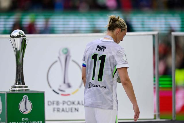 VfL Wolfsburg's German forward #11 Alexandra Popp reacts passed the cup after the end of the Women's German Cup (DFB-Pokal) final football match between VfL Wolfsburg and FC Bayern Munich in Cologne, western Germany, on Mai 14, 2026. (Photo by INA FASSBENDER / AFP) / DFB REGULATIONS PROHIBIT ANY USE OF PHOTOGRAPHS AS IMAGE SEQUENCES AND QUASI-VIDEO.