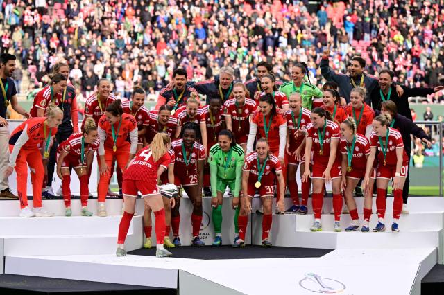 Team FC Bayern Munich celebrates winning the Women's German Cup (DFB-Pokal) final football match between VfL Wolfsburg and FC Bayern Munich in Cologne, western Germany, on Mai 14, 2026. (Photo by INA FASSBENDER / AFP) / DFB REGULATIONS PROHIBIT ANY USE OF PHOTOGRAPHS AS IMAGE SEQUENCES AND QUASI-VIDEO.