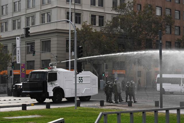 Riot police throw water at highschool and University students during a demonstration against the government of Chile's President Jose Antonio Kast in Santiago on May 14, 2026. (Photo by RODRIGO ARANGUA / AFP)