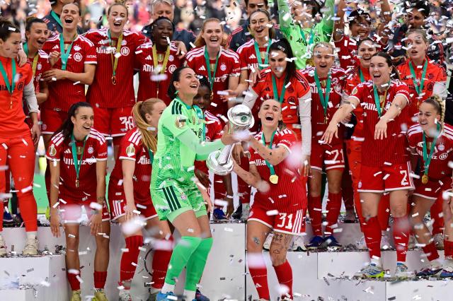 Bayern Munich's English midfielder #31 Georgia Stanway (C-R) and Bayern Munich's German goalkeeper #01 Maria Luisa Grohs (C-L) raise the trophy as team FC Bayern Munich celebrates winning the Women's German Cup (DFB Pokal) Women's German Cup (DFB-Pokal) final football match between VfL Wolfsburg and FC Bayern Munich in Cologne, western Germany, on Mai 14, 2026. (Photo by INA FASSBENDER / AFP) / DFB REGULATIONS PROHIBIT ANY USE OF PHOTOGRAPHS AS IMAGE SEQUENCES AND QUASI-VIDEO.