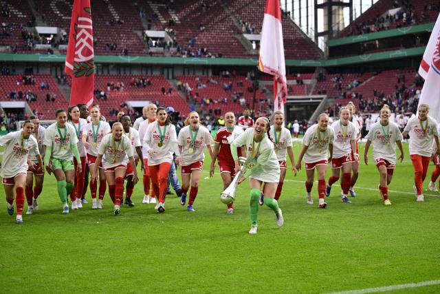 Team FC Bayern Munich celebrates with the trophy after winning the Women's German Cup (DFB-Pokal) final football match between VfL Wolfsburg and FC Bayern Munich in Cologne, western Germany, on Mai 14, 2026. (Photo by INA FASSBENDER / AFP) / DFB REGULATIONS PROHIBIT ANY USE OF PHOTOGRAPHS AS IMAGE SEQUENCES AND QUASI-VIDEO.