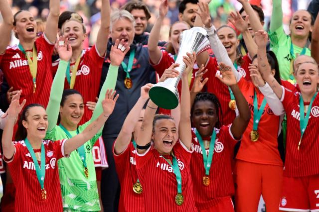 Team FC Bayern Munich celebrates with the trophy raised by Bayern Munich's Italian midfielder #27 Arianna Caruso (C) after winning the Women's German Cup (DFB Pokal) Women's German Cup (DFB-Pokal) final football match between VfL Wolfsburg and FC Bayern Munich in Cologne, western Germany, on Mai 14, 2026. (Photo by INA FASSBENDER / AFP) / DFB REGULATIONS PROHIBIT ANY USE OF PHOTOGRAPHS AS IMAGE SEQUENCES AND QUASI-VIDEO.