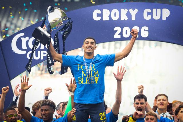 Royale Union Saint-Gilloise's Israeli forward #25 Anan Khalaili (C) raises the trophy as Royale Union Saint-Gilloise's team celebrates on the podium after winning the Belgian "Croky Cup" football final match between Royale Union Saint-Gilloise and RSC Anderlecht in Brussels on May 14, 2026. (Photo by VIRGINIE LEFOUR / BELGA / AFP) / Belgium OUT