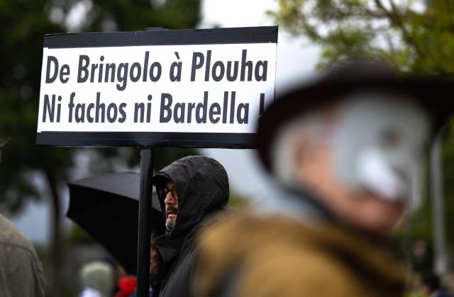 People protest during the opening of a brewery by journalist and far-right activist Erik Tegner in Pleguien, western France on May 14, 2026. Tegner, a commentator on CNews television and co-founder of the far-right outlet Frontières, opened the Kerfave craft brewery alongside a business partner in the Cotes-d'Armor department, with anti-fascist groups mobilising against the launch. (Photo by Fred TANNEAU / AFP)