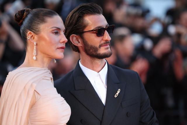 French actor Pierre Niney and his wife Australian actress Natasha Andrews arrive for the screening of the film "Histoires Paralleles" (Parallel Tales) at the 79th edition of the Cannes Film Festival in Cannes, southern France on May 14, 2026. (Photo by Valery HACHE / AFP)