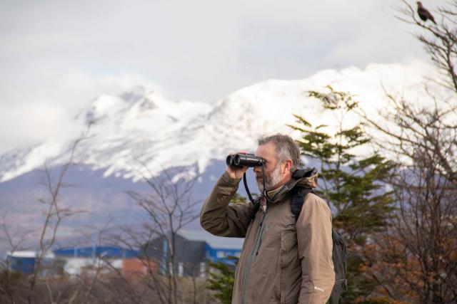 Argentine tourist guide specializing in birdwatching and nature photography Esteban Daniels observes birds such as the white-lined hawk (Daptrius albogularis) and other carrion birds at a municipal landfill in Ushuaia, Tierra del Fuego province, Argentina, on May 14, 2026. A team of Argentine scientists will travel to the southern port city of Ushuaia next week to determine whether hantavirus is present there, health authorities said on May 14. (Photo by CRISTIAN URRUTIA / AFP)