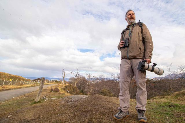 Argentine tourist guide specializing in birdwatching and nature photography Esteban Daniels observes birds such as the white-lined hawk (Daptrius albogularis) and other carrion birds at a municipal landfill in Ushuaia, Tierra del Fuego province, Argentina, on May 14, 2026. A team of Argentine scientists will travel to the southern port city of Ushuaia next week to determine whether hantavirus is present there, health authorities said on May 14. (Photo by CRISTIAN URRUTIA / AFP)
