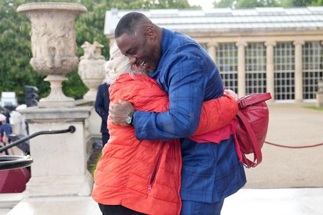 Actor Idris Elba embraces his former drama teacher a Royal Garden Party at Buckingham Palace, in London, on May 14, 2026, celebrating the 50th Anniversary of the King’s Trust. (Photo by Aaron Chown / POOL / AFP)