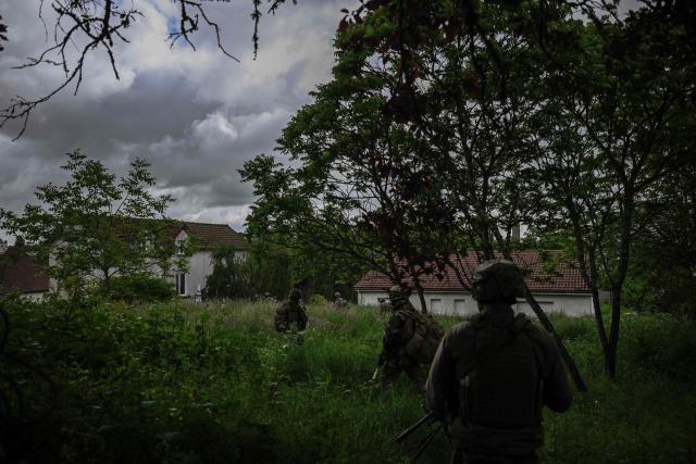 French Foreign Legion paratroopers from the 2nd Foreign Parachute Regiment (2e REP) advance through undergrowth towards a built-up area during a urban assault exercise in La Souterraine, central France, on May 14, 2026. The exercise, running from May 11 to 20 across Nouvelle-Aquitaine and Centre-Val de Loire, tests short-notice redeployment and interoperability between air and ground components — capabilities central to France's contribution to NATO rapid-reaction forces. (Photo by Philippe LOPEZ / AFP)