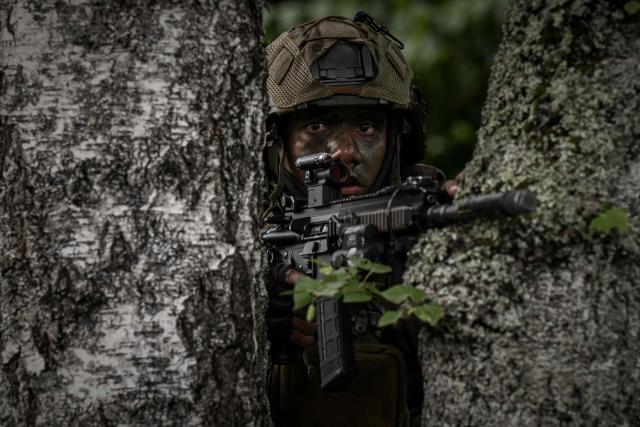 A French Foreign Legion paratrooper from the 2nd Foreign Parachute Regiment (2e REP) takes aim from behind a tree during a urban assault exercise in La Souterraine, central France, on May 14, 2026. The exercise, running from May 11 to 20 across Nouvelle-Aquitaine and Centre-Val de Loire, tests short-notice redeployment and interoperability between air and ground components — capabilities central to France's contribution to NATO rapid-reaction forces. (Photo by Philippe LOPEZ / AFP)