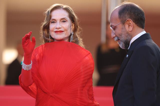 French actress Isabelle Huppert and Iranian director Asghar Farhadi arrive for the screening of the film "Histoires Paralleles" (Parallel Tales) at the 79th edition of the Cannes Film Festival in Cannes, southern France on May 14, 2026. (Photo by Valery HACHE / AFP)