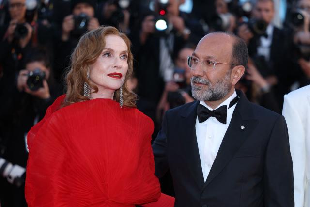 French actress Isabelle Huppert and Iranian director Asghar Farhadi arrive for the screening of the film "Histoires Paralleles" (Parallel Tales) at the 79th edition of the Cannes Film Festival in Cannes, southern France on May 14, 2026. (Photo by Sameer AL-DOUMY / AFP)