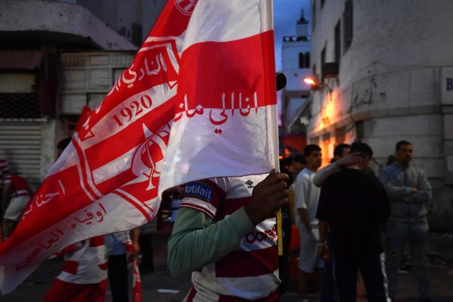 Fan carries a flag while celebrating the victory title of the Club Africain football team in the 2025/2026 Tunisian Ligue 1 championship, in Tunis on May 14, 2026. (Photo by FETHI BELAID / AFP)