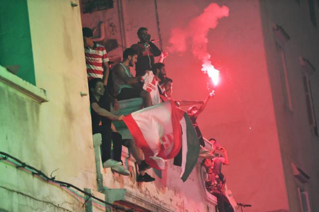 Fans light a flare during the victory ceremony of the Club Africain football team in the 2025/2026 Tunisian Ligue 1 championship, in Tunis on May 14, 2026. (Photo by FETHI BELAID / AFP)