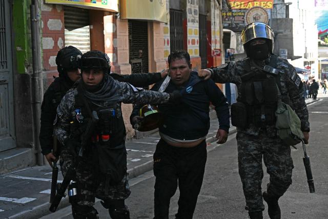 Riot police deatain a miners after clashes erupted during a march to demand the resignation of Bolivian President Rodrigo Paz in La Paz, on May 14, 2026. For the past two weeks, workers, farmers, school teachers, Indigenous groups and transport workers have been pressuring the government. Their demands range from wage increases and economic stabilization to opposition to the privatization of public companies. (Photo by AIZAR RALDES / AFP)