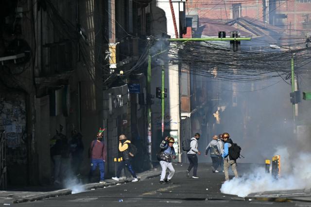 Miners clash with riot police during a march to demand the resignation of Bolivian President Rodrigo Paz in La Paz, on May 14, 2026. For the past two weeks, workers, farmers, school teachers, Indigenous groups and transport workers have been pressuring the government. Their demands range from wage increases and economic stabilization to opposition to the privatization of public companies. (Photo by AIZAR RALDES / AFP)