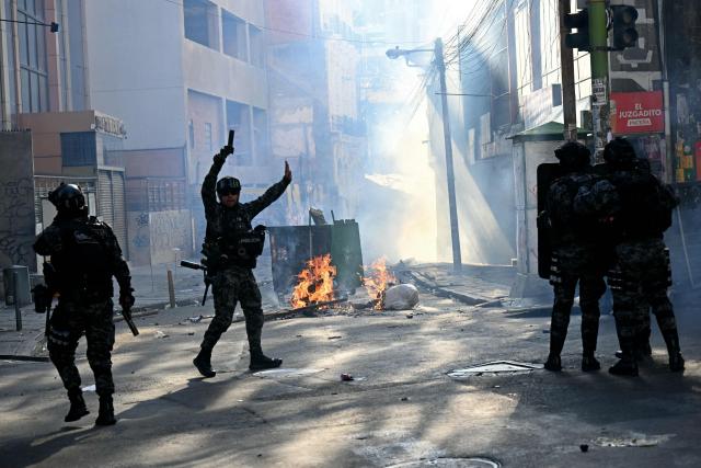 Riot police clash with miners during a march to demand the resignation of Bolivian President Rodrigo Paz, in La Paz, on May 14, 2026. For the past two weeks, workers, farmers, school teachers, Indigenous groups and transport workers have been pressuring the government. Their demands range from wage increases and economic stabilization to opposition to the privatization of public companies. (Photo by AIZAR RALDES / AFP)