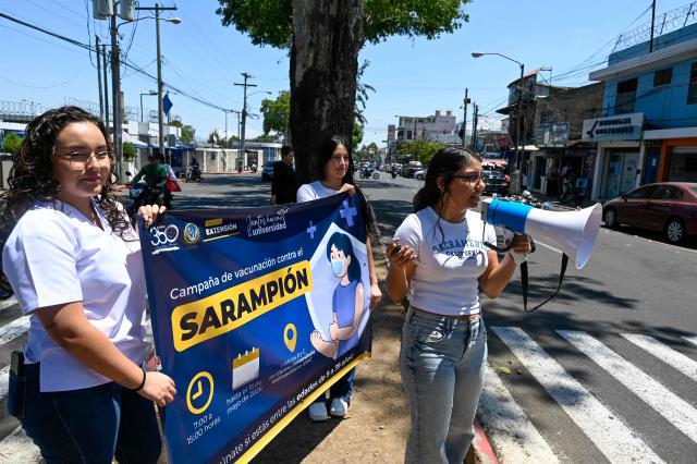 Medical students hold a sign during a campaign against measles outside Metropolitan University Centre in Guatemala City on 14, 2026. (Photo by Johan ORDONEZ / AFP)