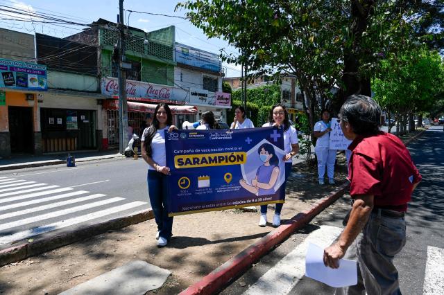 Medical students hold a sign during a campaign against measles outside Metropolitan University Centre in Guatemala City on 14, 2026. (Photo by Johan ORDONEZ / AFP)