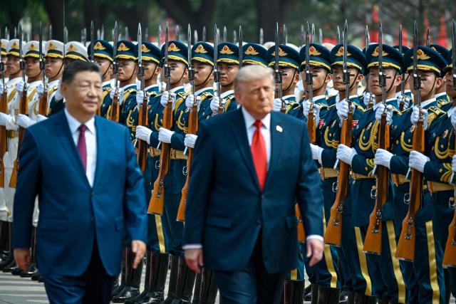 US President Donald Trump (R) and China's President Xi Jinping inspect a guard of honour during a welcome ceremony at the Great Hall of the People in Beijing on May 14, 2026. (Photo by Kenny HOLSTON / POOL / AFP)