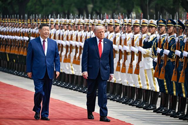 US President Donald Trump (R) and China's President Xi Jinping inspect a guard of honour during a welcome ceremony at the Great Hall of the People in Beijing on May 14, 2026. (Photo by Kenny HOLSTON / POOL / AFP)
