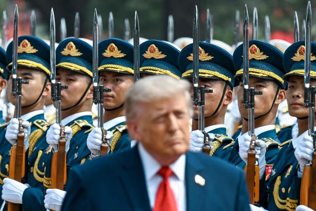 US President Donald Trump inspects a guard of honour during a welcome ceremony at the Great Hall of the People in Beijing on May 14, 2026. (Photo by Kenny HOLSTON / POOL / AFP)