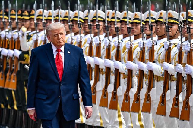 US President Donald Trump inspects a guard of honour during a welcome ceremony at the Great Hall of the People in Beijing on May 14, 2026. (Photo by Kenny HOLSTON / POOL / AFP)