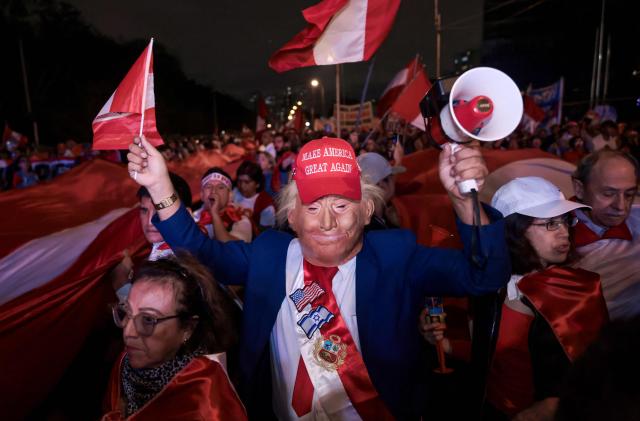 A supporter of Peru's presidential candidate for the Renovacion Popular party, Rafael Lopez Aliaga, dressed as US President Donald Trump, attends a rally to protest alleged irregularities in the recent elections in Lima on May 14, 2026. (Photo by Connie FRANCE / AFP)