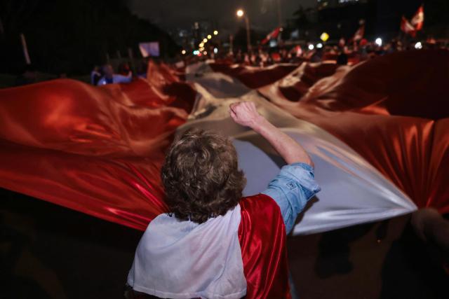 A supporter of Peru's presidential candidate for the Renovacion Popular party, Rafael Lopez Aliaga, attends a rally to protest alleged irregularities in the recent elections in Lima on May 14, 2026. (Photo by Connie FRANCE / AFP)