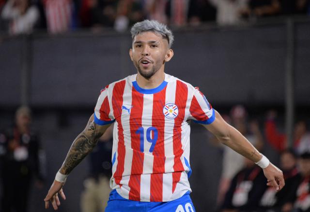 (FILES) Paraguay's forward #19 Julio Enciso celebrates after scoring from the penalty spot during the 2026 FIFA World Cup South American qualifiers football match between Paraguay and Uruguay at the Defensores del Chaco stadium in Asuncion on June 5, 2025. Those who know him attest that Julio Enciso fears no challenges, nor does he ever lose touch with his roots. That "mita'i" (little boy)—who once spoke more Guaranн than Spanish—is today not only a 22-year-old man, but also Paraguay's hope for its return to the World Cup. (Photo by DANIEL DUARTE / AFP)