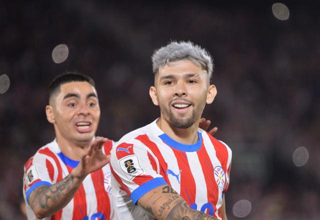 (FILES) Paraguay's forward #19 Julio Enciso celebrates after scoring from the penalty spot with teammate midfielder #10 Miguel Almiron during the 2026 FIFA World Cup South American qualifiers football match between Paraguay and Uruguay at the Defensores del Chaco stadium in Asuncion on June 5, 2025. Those who know him attest that Julio Enciso fears no challenges, nor does he ever lose touch with his roots. That "mita'i" (little boy)—who once spoke more Guaranн than Spanish—is today not only a 22-year-old man, but also Paraguay's hope for its return to the World Cup. (Photo by DANIEL DUARTE / AFP)