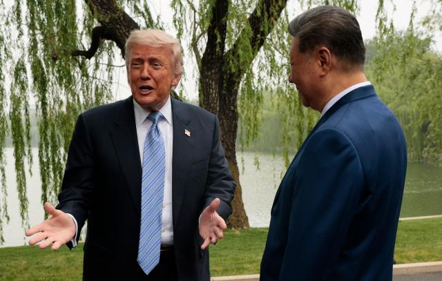 US President Donald Trump (L) speaks as he is greeted by Chinese President Xi Jinping at Zhongnanhai Garden in Beijing on May 15, 2026. (Photo by Evan Vucci / POOL / AFP)