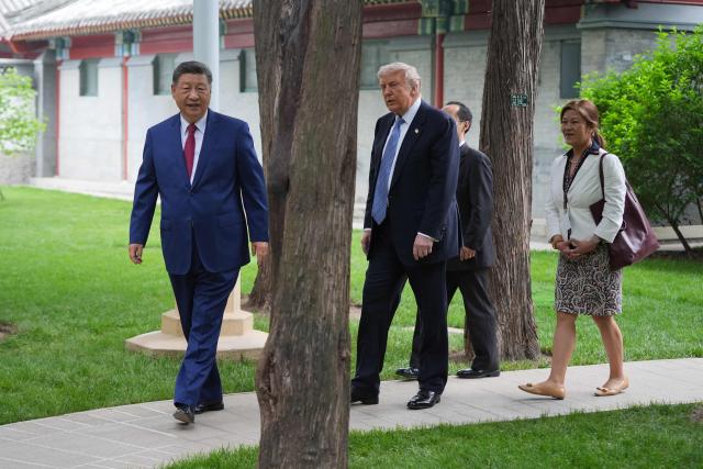 President Donald Trump (C) walks with China’s President Xi Jinping (L) at the Zhongnanhai leadership compound in Beijing on May 15, 2026. (Photo by Mark Schiefelbein / POOL / AFP)