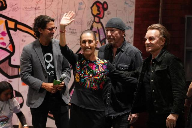 This handout picture released by Mexican Presidency shows Mexico's President Claudia Sheinbaum (C-L) greeting U2 band members Bono (R) and The Edge (C-R) during an event in Mexico City on May 14, 2026. (Photo by Handout / Mexican Presidency / AFP)