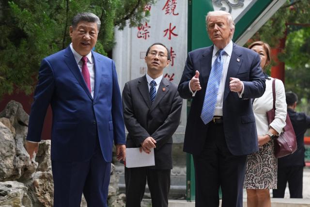 US President Donald Trump (R) and China’s President Xi Jinping (L) visit the Zhongnanhai leadership compound in Beijing on May 15, 2026. (Photo by Mark Schiefelbein / POOL / AFP)