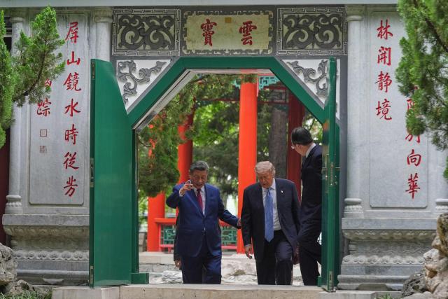 US President Donald Trump (2nd R) walks with China’s President Xi Jinping (L) at the Zhongnanhai leadership compound in Beijing on May 15, 2026. (Photo by Mark Schiefelbein / POOL / AFP)