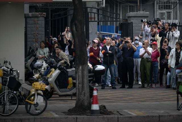 People watch the motorcade of US President Donald Trump as it travels to the Zhongnanhai leadership compound for a meeting with China’s President Xi Jinping in Beijing on May 15, 2026. (Photo by Brendan Smialowski / AFP)