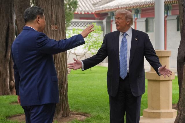 US President Donald Trump (R) talks to China’s President Xi Jinping at the Zhongnanhai leadership compound in Beijing on May 15, 2026. (Photo by Mark Schiefelbein / POOL / AFP)