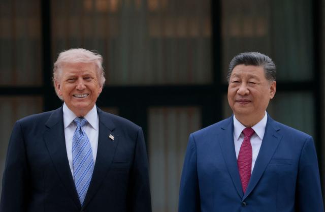 US President Donald Trump (L) poses for photos with China’s President Xi Jinping during a visit to Zhongnanhai Garden in Beijing on May 15, 2026. (Photo by Evan Vucci / POOL / AFP)