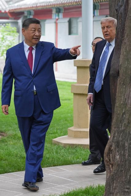 US President Donald Trump (R) talks to China’s President Xi Jinping (L) at the Zhongnanhai leadership compound in Beijing on May 15, 2026. (Photo by Mark Schiefelbein / POOL / AFP)