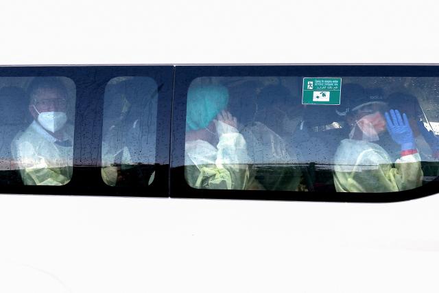 A bus carrying passengers caught up in the MV Hondius hantavirus outbreak, arrives at a purpose-built quarantine facility located on the outskirts of the Western Australian city of Perth on May 15, 2026. A plane carrying six passengers caught up in the hantavirus outbreak on the MV Hondius cruise ship landed May 15 at a military airbase in western Australia, where they will immediately enter a strict three-week quarantine. (Photo by Antony DICKSON / AFP)