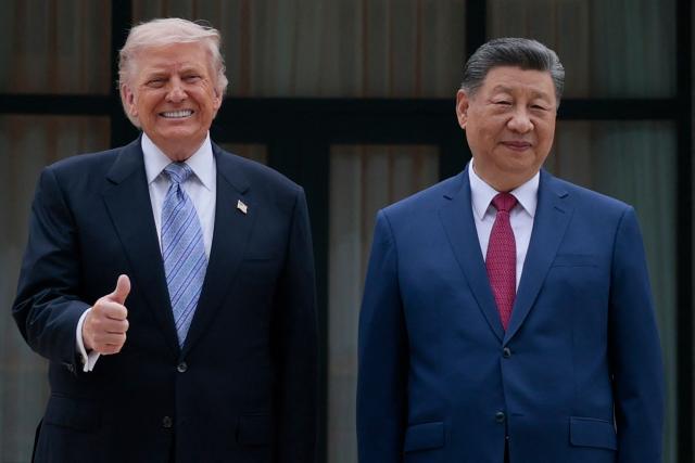 US President Donald Trump (L) poses for photos with China’s President Xi Jinping during a visit to Zhongnanhai Garden in Beijing on May 15, 2026. (Photo by Evan Vucci / POOL / AFP)