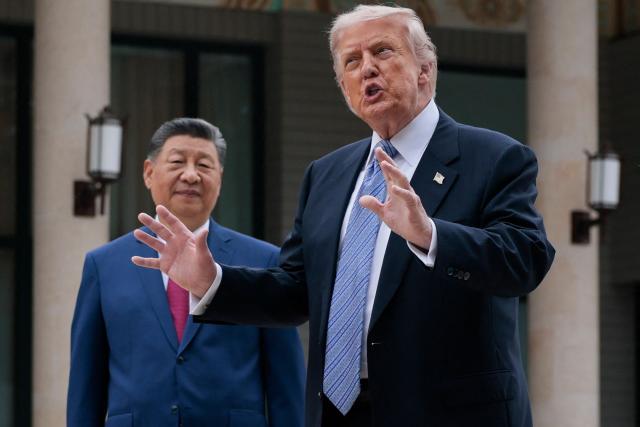 US President Donald Trump (R) gestures as he poses for photos with China’s President Xi Jinping during a visit to Zhongnanhai Garden in Beijing on May 15, 2026. (Photo by Evan Vucci / POOL / AFP)