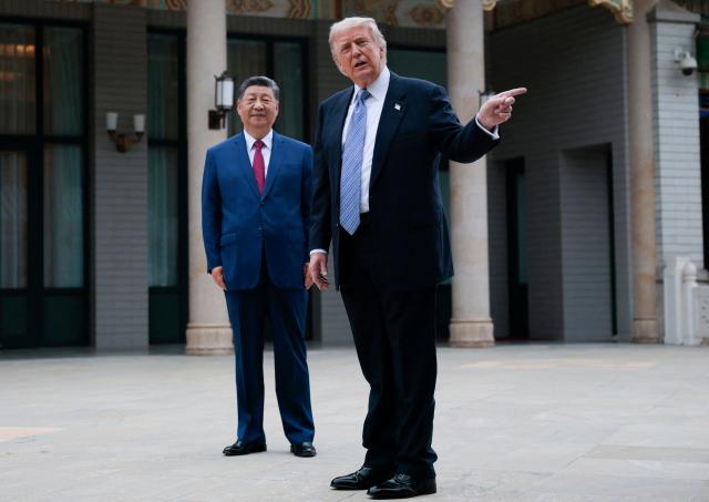 US President Donald Trump (R) gestures as he poses for photos with China’s President Xi Jinping during a visit to Zhongnanhai Garden in Beijing on May 15, 2026. (Photo by Evan Vucci / POOL / AFP)