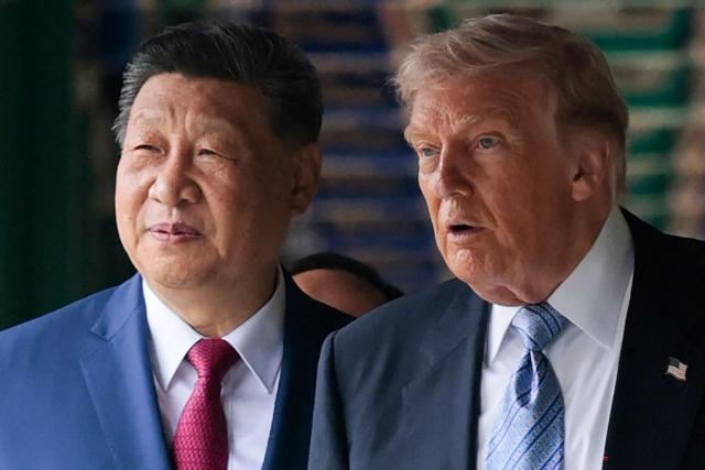 US President Donald Trump (R) walks with China’s President Xi Jinping at Zhongnanhai Garden in Beijing on May 15, 2026. (Photo by Evan Vucci / POOL / AFP)