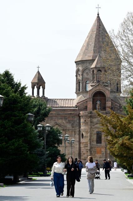 People walk outside the Etchmiadzin Cathedral in Echmiadzin, Armenia's ancient spiritual centre and the seat of the leader of the Armenian Apostolic Church, outside Yerevan, on April 18, 2026. (Photo by KAREN MINASYAN / AFP)