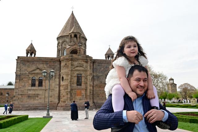 People walk outside the Etchmiadzin Cathedral in Echmiadzin, Armenia's ancient spiritual centre and the seat of the leader of the Armenian Apostolic Church, outside Yerevan, on April 18, 2026. (Photo by KAREN MINASYAN / AFP)